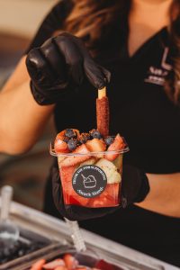 Hannah Serraino - Snack Sized Food Cart Owner holding a fruit cup with tajin in Santa Clarita CA